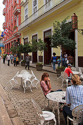 people at tables in street